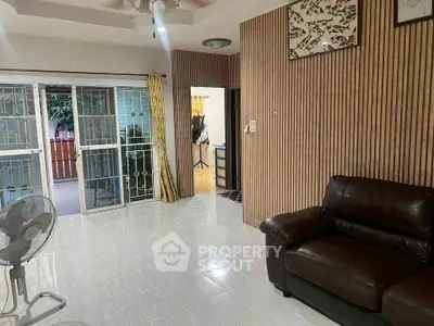 Spacious living room with modern decor and sliding glass doors leading to a balcony.