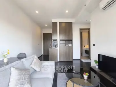 Modern living room with sleek furniture and open layout, featuring a cozy sofa and stylish decor.