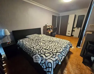 Spacious bedroom with modern decor and ample storage in a stylish apartment.