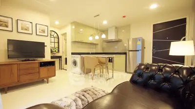 Modern living room with open kitchen, leather sofa, and appliances
