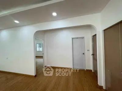 Spacious interior with wooden flooring and modern lighting, ideal for versatile living arrangements.