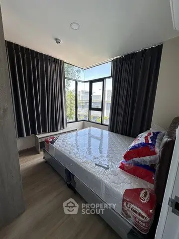 Modern bedroom with large windows and stylish curtains in a contemporary apartment.