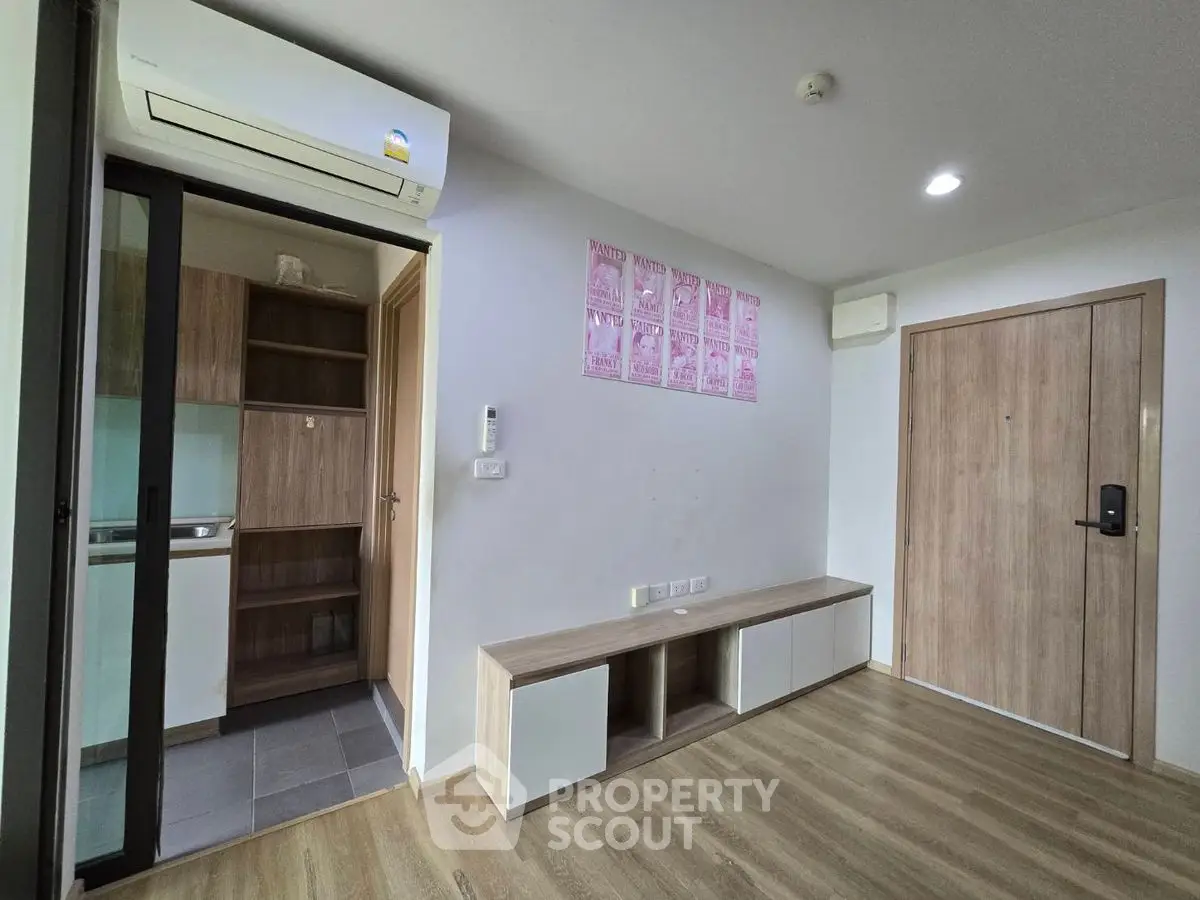 Modern apartment interior with wooden flooring and built-in storage units.