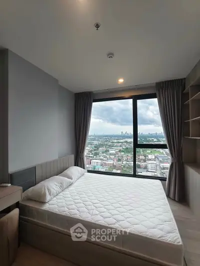 Modern bedroom with stunning city view from large window, featuring sleek design and ample natural light.