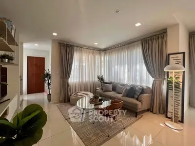 Elegant living room with large windows, stylish furniture, and cozy ambiance.