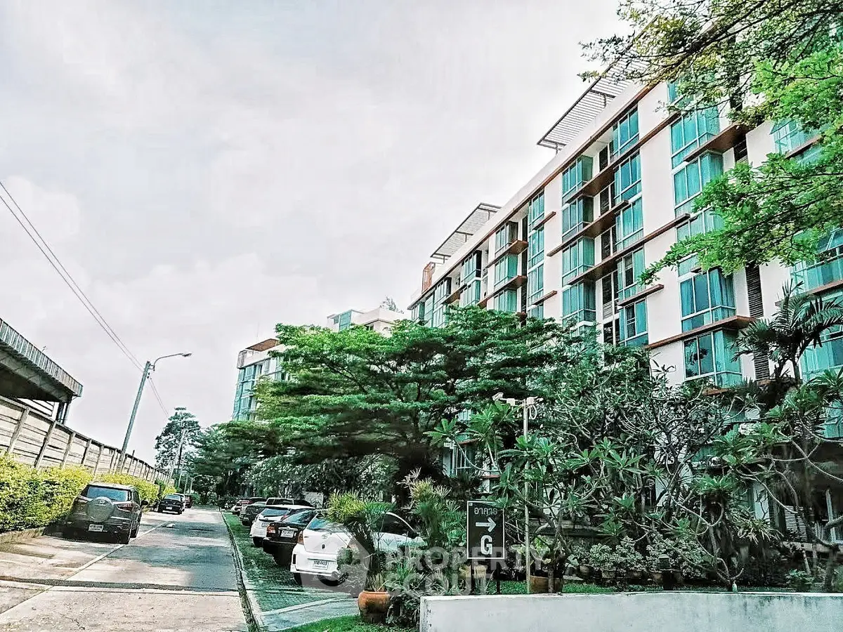 Modern residential building with lush greenery and ample parking space