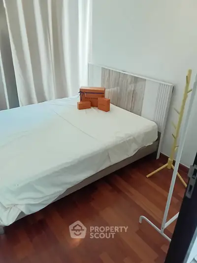 Cozy bedroom with wooden flooring and stylish decor, perfect for relaxation.