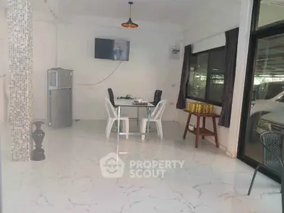 Modern dining area with marble flooring and large windows in a stylish home.