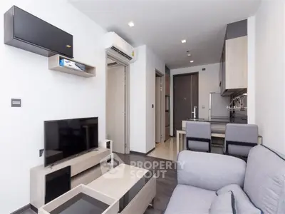 Modern living room with sleek furniture and open kitchen layout in a stylish apartment.