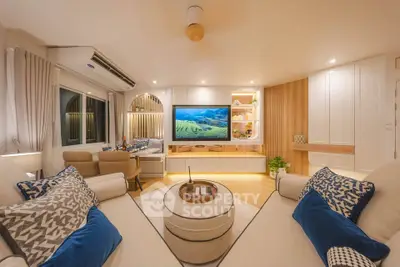 Luxurious modern living room with elegant decor and large TV, perfect for relaxation and entertainment.