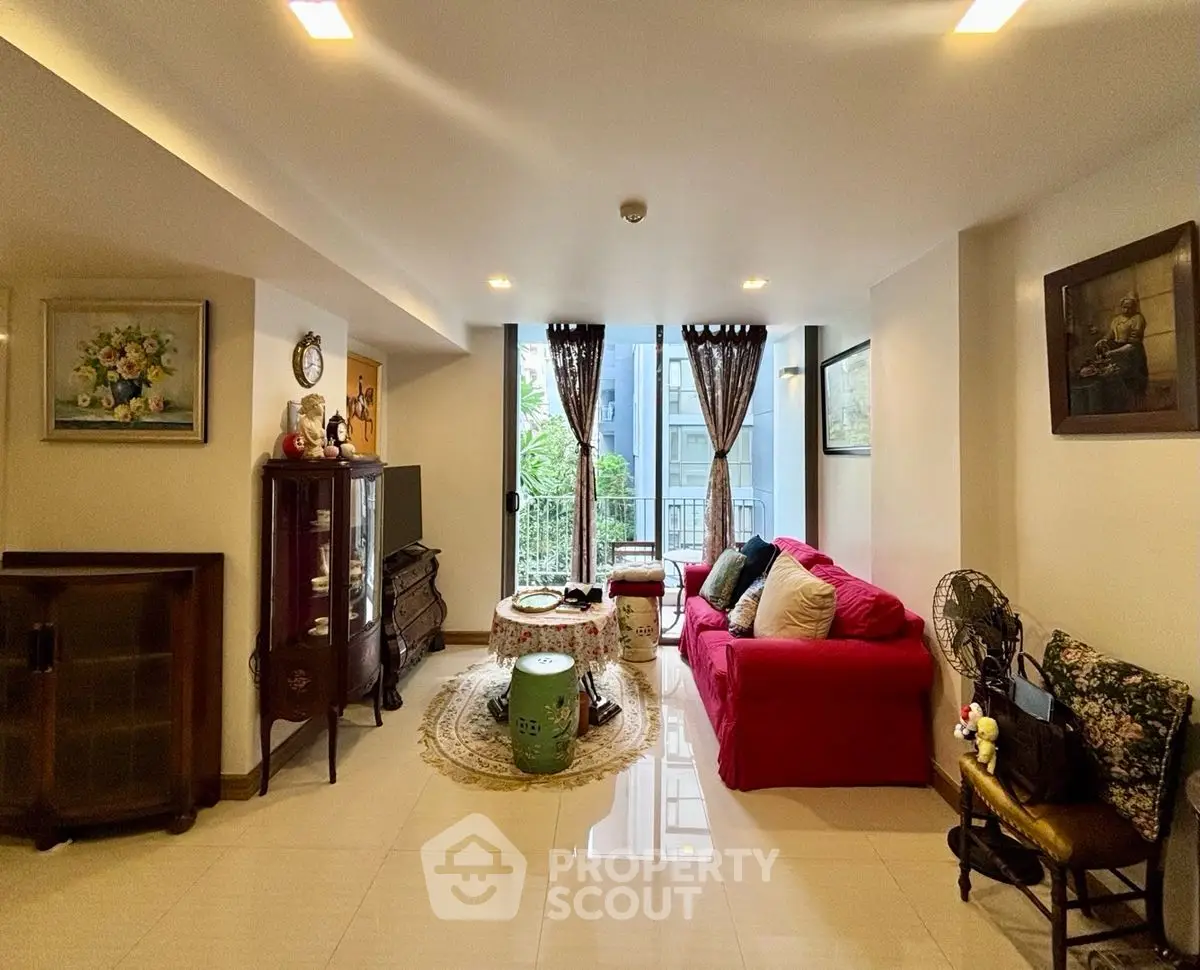 Charming living room with vibrant red sofa and elegant decor, featuring a cozy seating area and natural light.