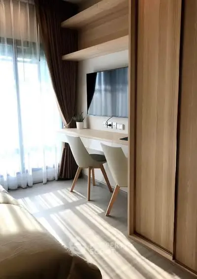 Modern bedroom with study area and natural light, featuring sleek furniture and elegant design.