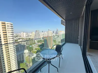 Stunning city view from modern balcony with glass railing and outdoor seating.