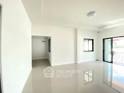 Spacious modern living room with large windows and glossy tiled floor.