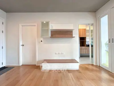 Modern minimalist living room with wooden flooring and sleek storage solutions.