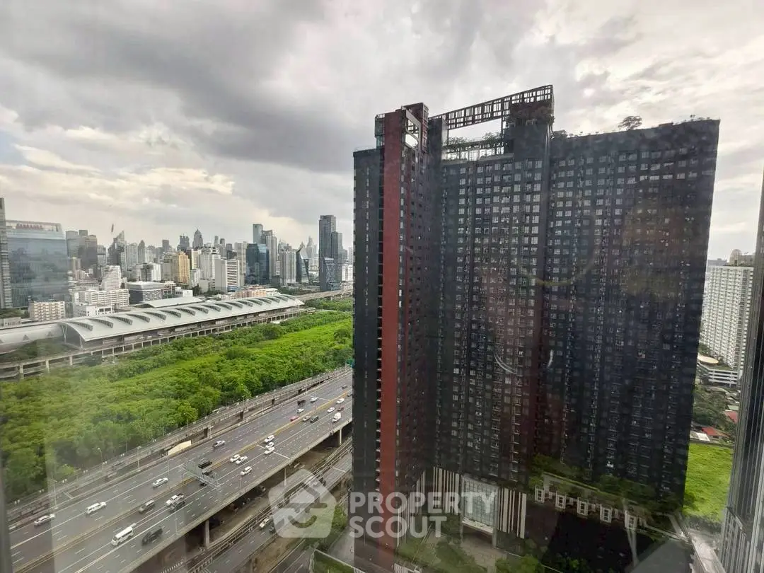 Stunning cityscape view from high-rise building with lush greenery and urban skyline.