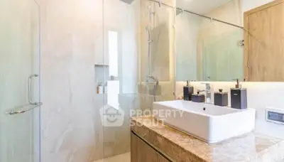 Luxurious modern bathroom with elegant fixtures and glass shower enclosure.