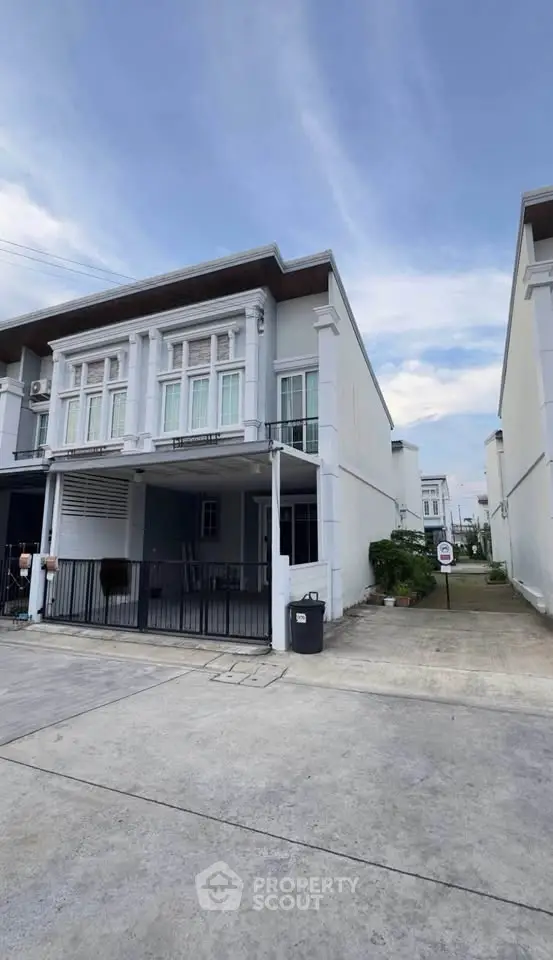 Modern two-story townhouse with clean facade and driveway in a serene neighborhood.