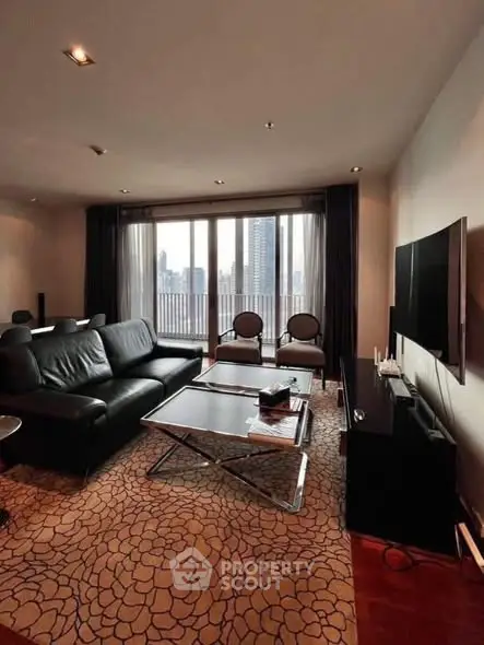 Luxurious living room with city view, featuring modern black leather sofa and large windows.