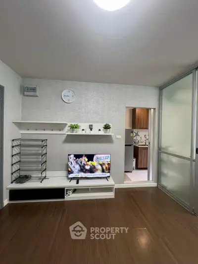 Modern living room with sleek TV setup and open kitchen view