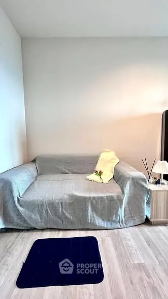 Cozy living room with a modern sofa and minimalist decor, perfect for relaxation.