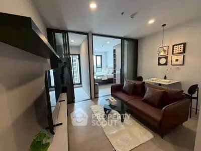 Modern living room with stylish decor and open layout leading to a cozy bedroom.