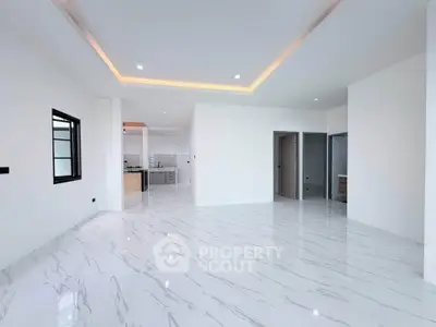 Spacious modern living room with sleek marble flooring and open kitchen layout