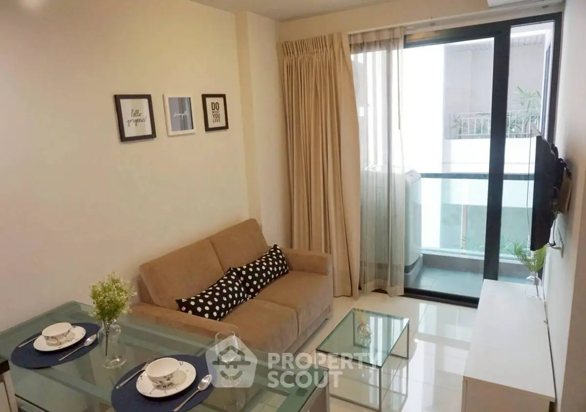 Modern living room with glass dining table and cozy sofa near balcony