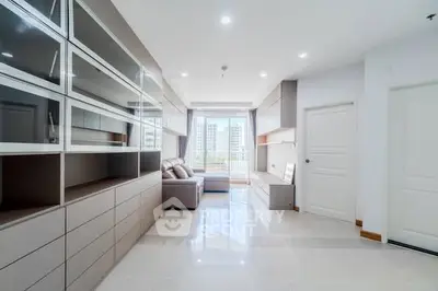 Spacious modern living room with large windows and stylish built-in storage.