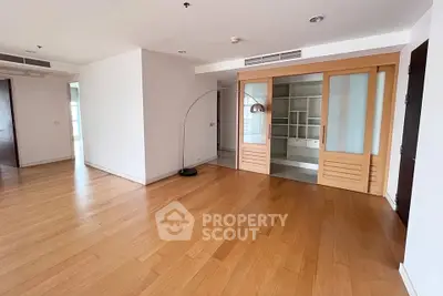 Spacious modern living room with wooden floors and sliding doors in a luxury apartment.