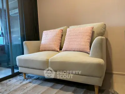 Cozy living room with stylish beige sofa and pink cushions