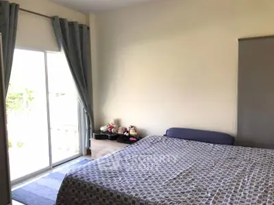 Cozy bedroom with large window and modern decor, perfect for relaxation and comfort.