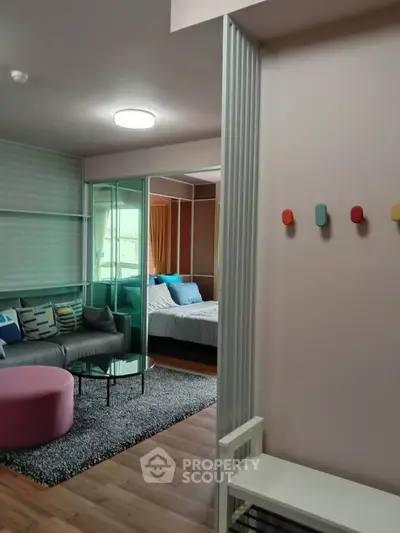 Modern living room with cozy seating and stylish decor adjacent to a comfortable bedroom