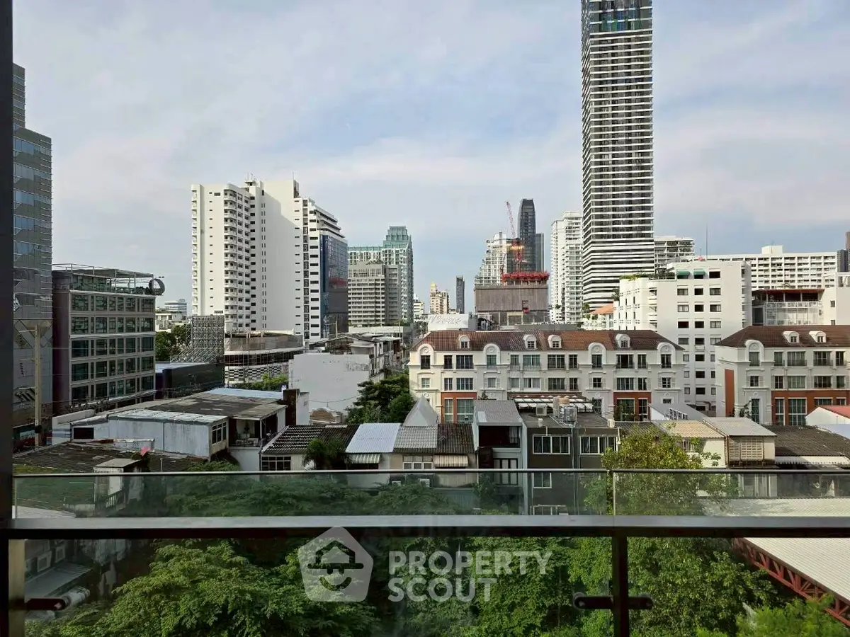 Stunning cityscape view from a high-rise balcony with lush greenery and modern architecture.