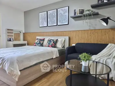 Modern bedroom with stylish decor, featuring a cozy bed, elegant sofa, and chic wall art.