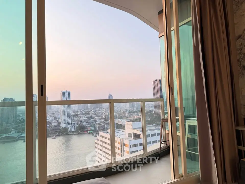 Stunning high-rise apartment with panoramic city and river views from a spacious balcony.