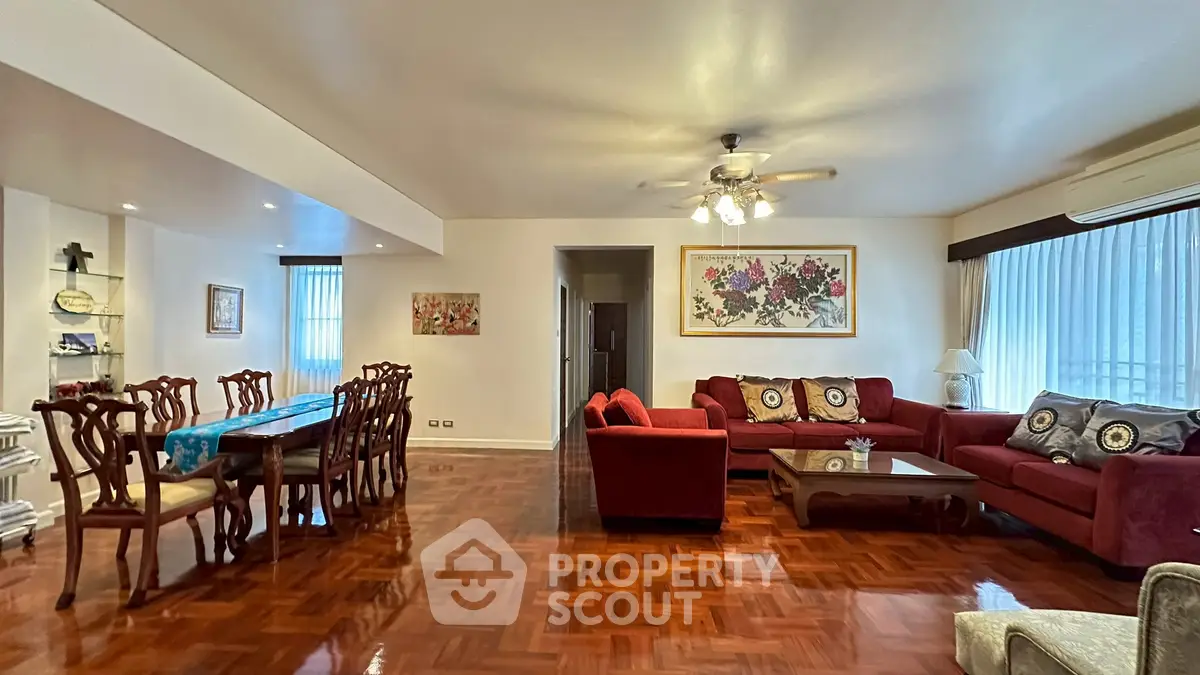 Spacious living room with elegant dining area and cozy seating, featuring polished wooden floors and stylish decor.