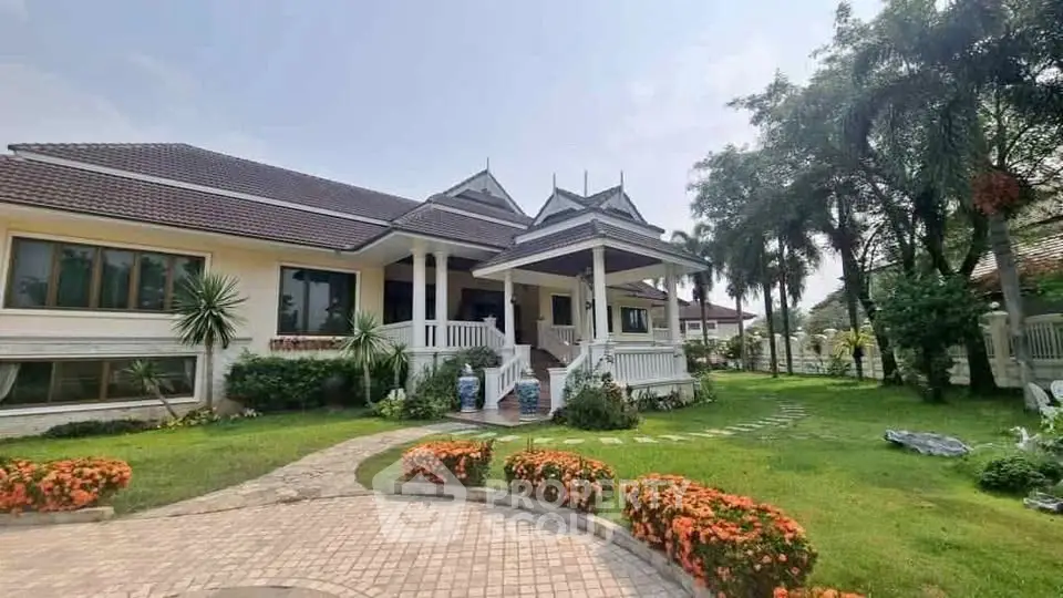 Charming single-story home with lush garden and traditional architectural elements.