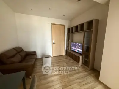 Cozy living room with modern furniture and wooden flooring, perfect for relaxation.