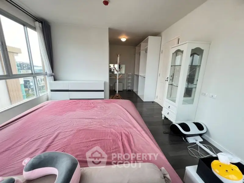 Spacious bedroom with modern furnishings and large windows offering natural light.