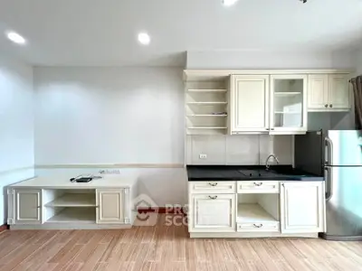 Modern kitchen with sleek cabinetry and stainless steel fridge in a bright, open space.