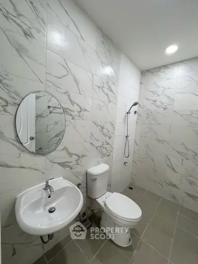 Modern bathroom with marble tiles and sleek fixtures in a contemporary real estate property.
