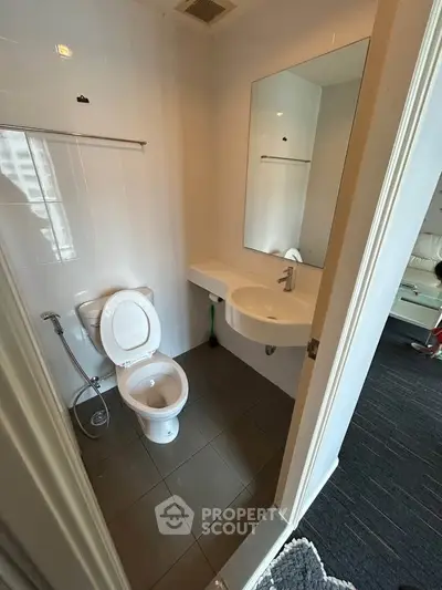 Compact modern bathroom with sleek fixtures and a large mirror, perfect for urban living.