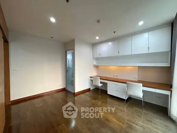 Spacious study room with built-in desk and ample storage in modern apartment
