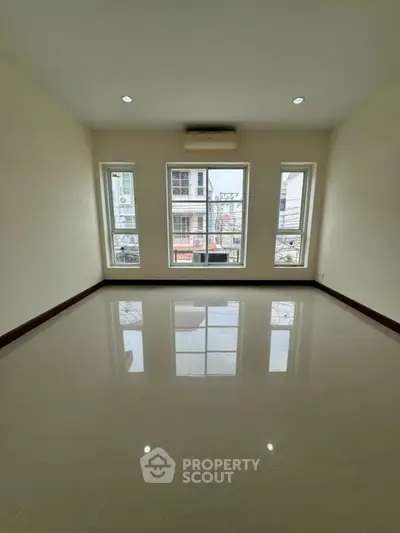 Spacious empty room with large windows and glossy floor, ideal for customization.