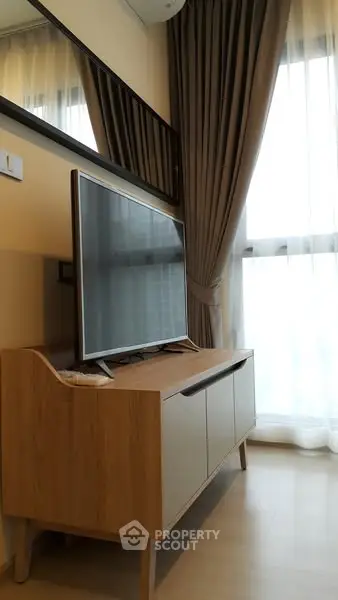 Modern living room with stylish TV stand and floor-to-ceiling curtains
