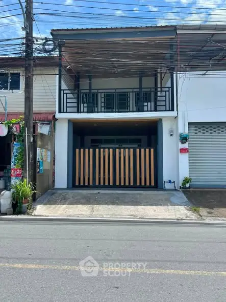 Modern townhouse exterior with gated entrance and balcony, ideal for urban living.
