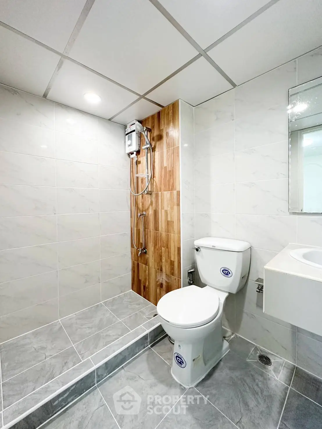 Modern bathroom with sleek design, featuring a shower and toilet in a stylish tiled setting.