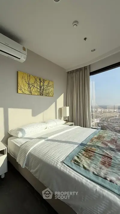 Modern bedroom with large window offering stunning city view, featuring cozy bed and elegant decor.