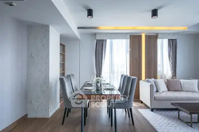 Elegant modern living room with dining area, featuring stylish furniture and natural light.